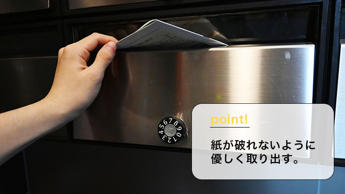 ダイヤル式ポストから詰まった郵便物を取り出す